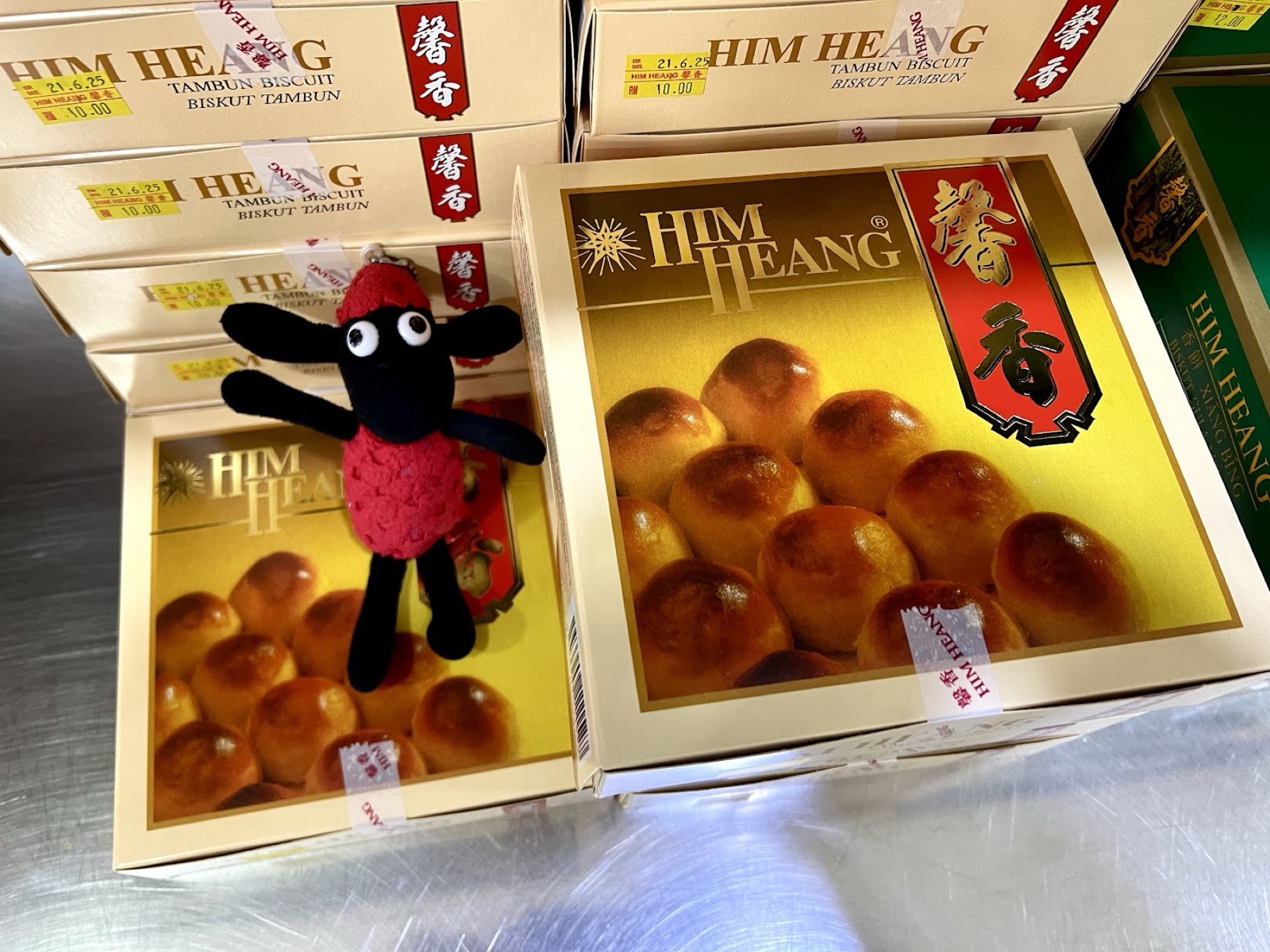 Gold and red Him Heang gift boxes of Tambun biscuits stacked on the counter