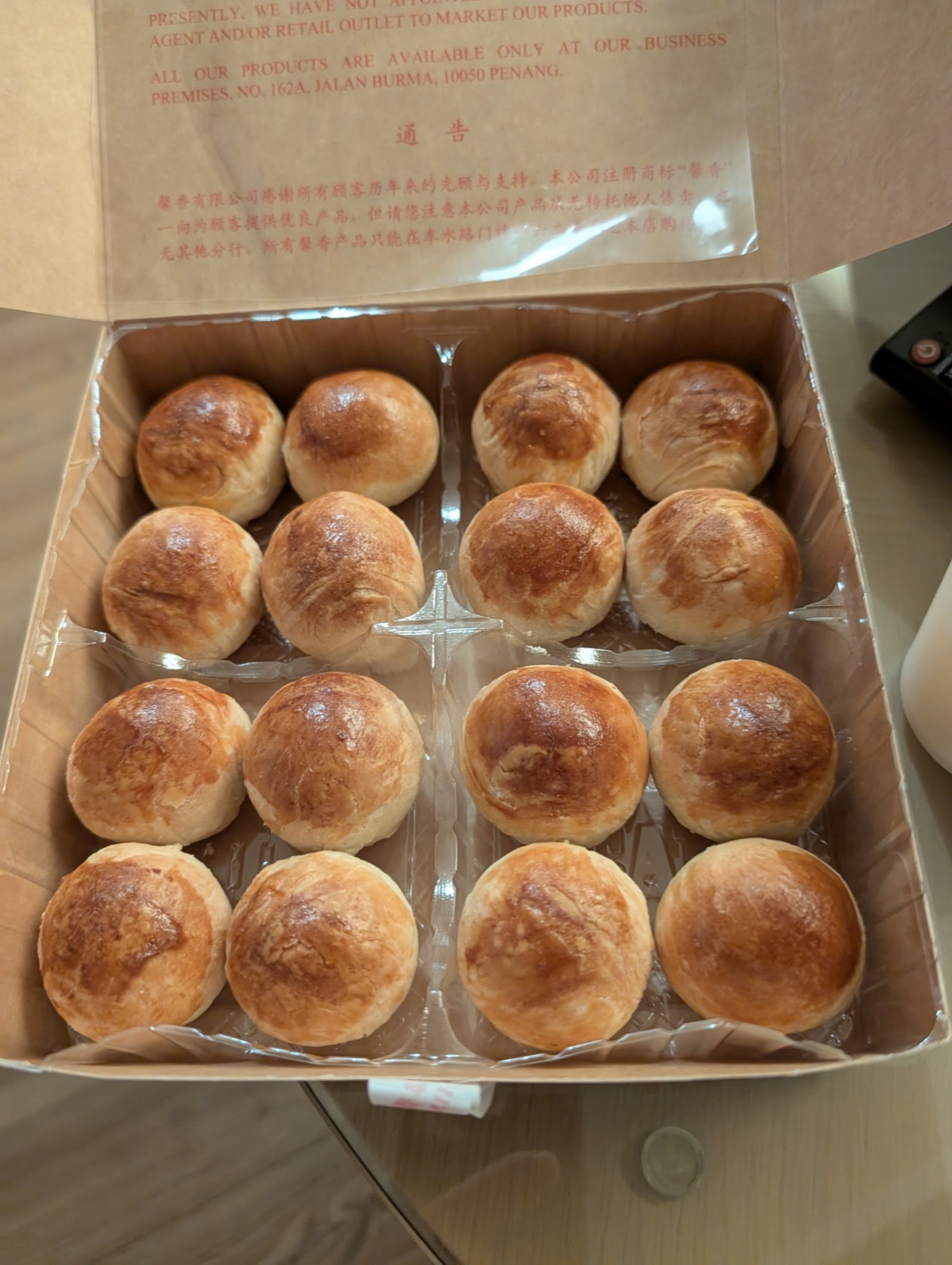 An open box of sixteen freshly baked Tau Sar Piah, golden domes in a neat grid